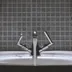 A bathroom tap running with water.